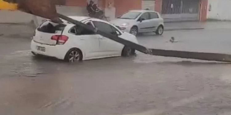Poste cai em cima de carro que passava por rua durante chuva, em Goiânia