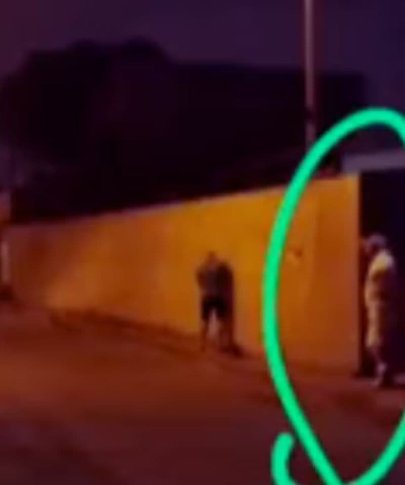 Policial urinando em muro